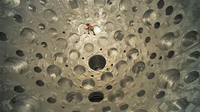 Physicist Vaughn Draggoo inspects a huge target chamber at the National Ignition Facility in Livermore, California in October 2001.