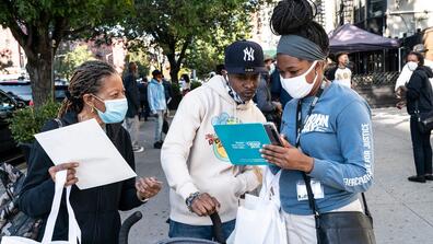 A Census worker helps people fill out their form