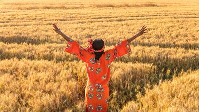 A woman in front of a wheat field