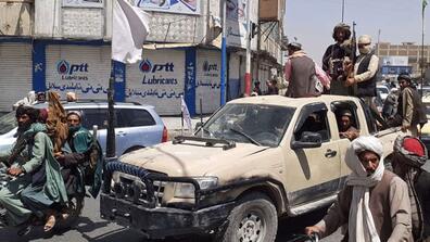 Taliban fighters drive an Afghan National Army (ANA) vehicle through a street in Kandahar on Aug. 13, 2021.