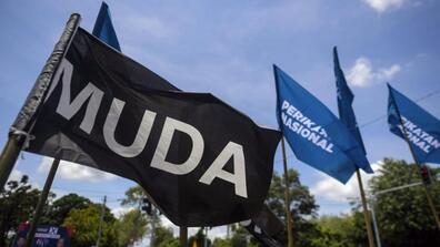 Flags that say MUDA (The Malaysian United Democratic Alliance) and "Perikatan Nasional" (Malaysia's National Alliance coalition)