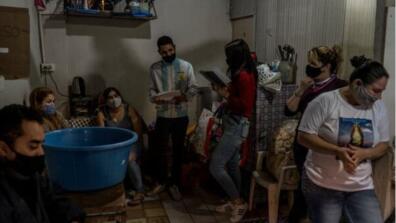 A group of people wearing masks in a dark room
