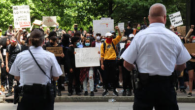 Police officers watch a public protest, Summer 2020