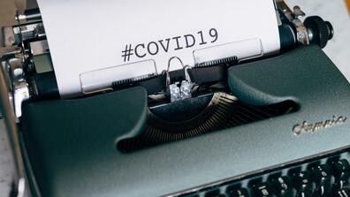 a typewriter that says COVID-19 on the paper