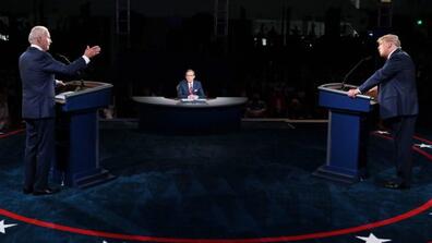 The presidential candidates stand at podiums on the debate stage