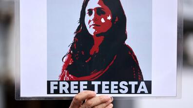 hand holding up a free teesta poster 