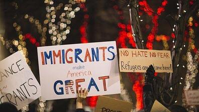 protestors hold up pro-immigration signs