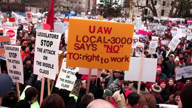 protestors hold signs supporting unions