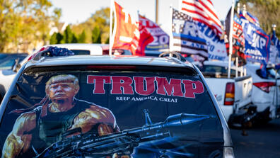 Cars with Donald Trump's campaign flags and posters