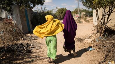 Two people walk down a street