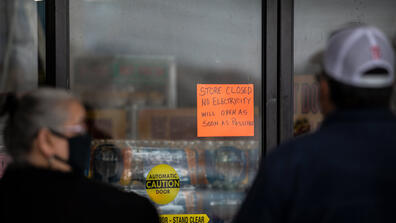 a sign on a door reads store closed due to a power outage